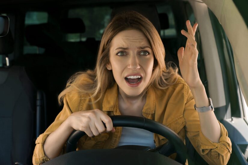 A confused woman by the wheel